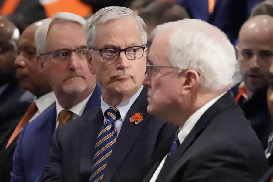 Chicago Bears chairman George McCaskey (C) listens as new head coach Ben Johnson answers questions during a introductory press conference at PNC Center.