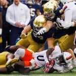 Notre Dame defensive lineman Bryce Young (30) tackles Virginia tight end Sage Ennis (0) during a NCAA college football game at Notre Dame Stadium on Saturday, Nov. 16, 2024, in South Bend.